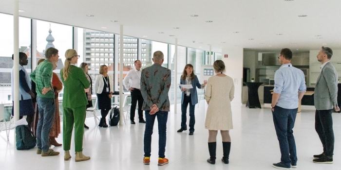 People standing in circle listening the speaker.